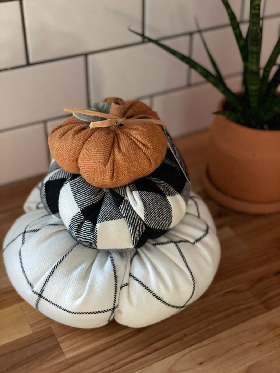 Orange, buffalo-check, and white stacked pumpkins